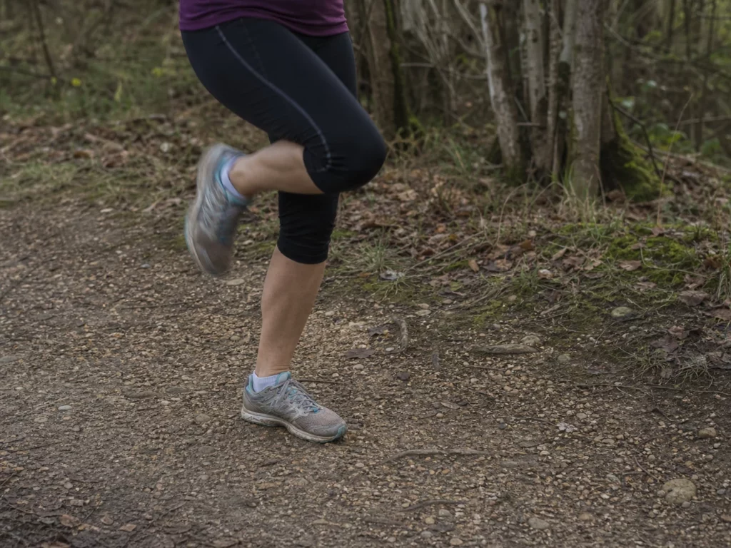 Jambes d'une coureuse pendant un exercice technique sur un chemin naturel
