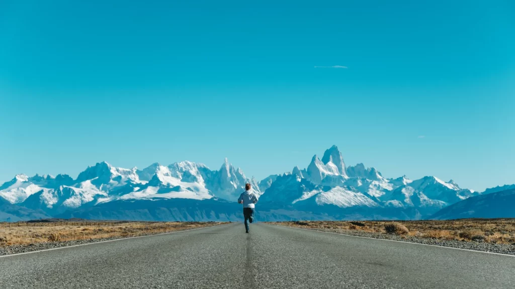 Coureur vu de dos sur une route de montagne
