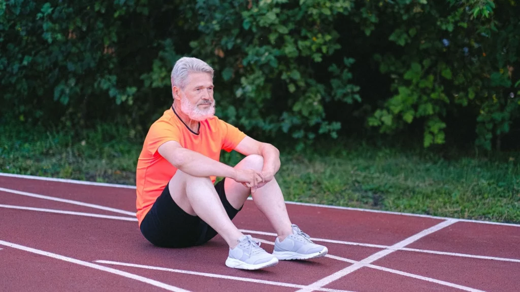Coureur assis sur une piste après son entraînement