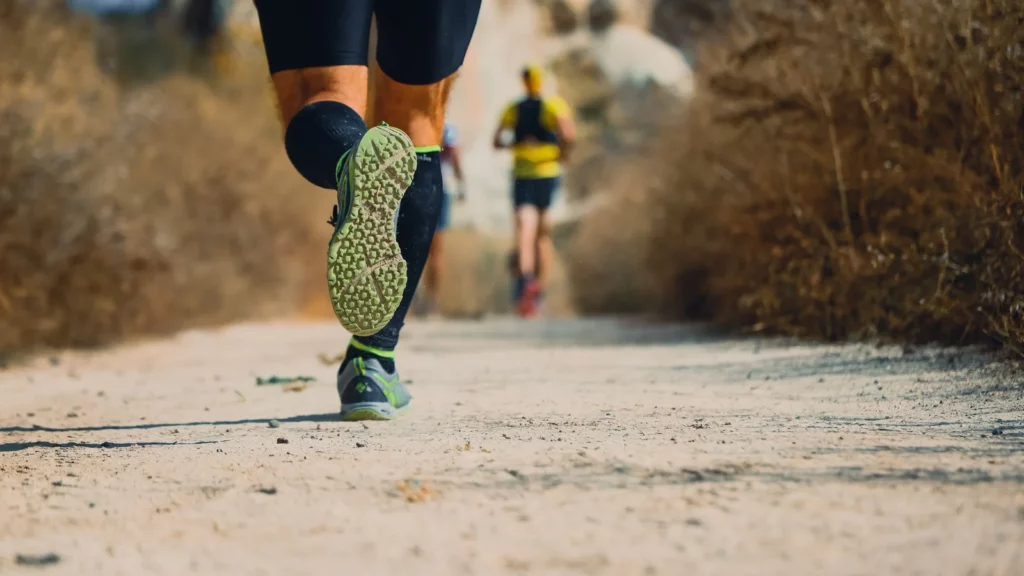 Semelle crantée d'une chaussure de trail pendant une course sur chemin