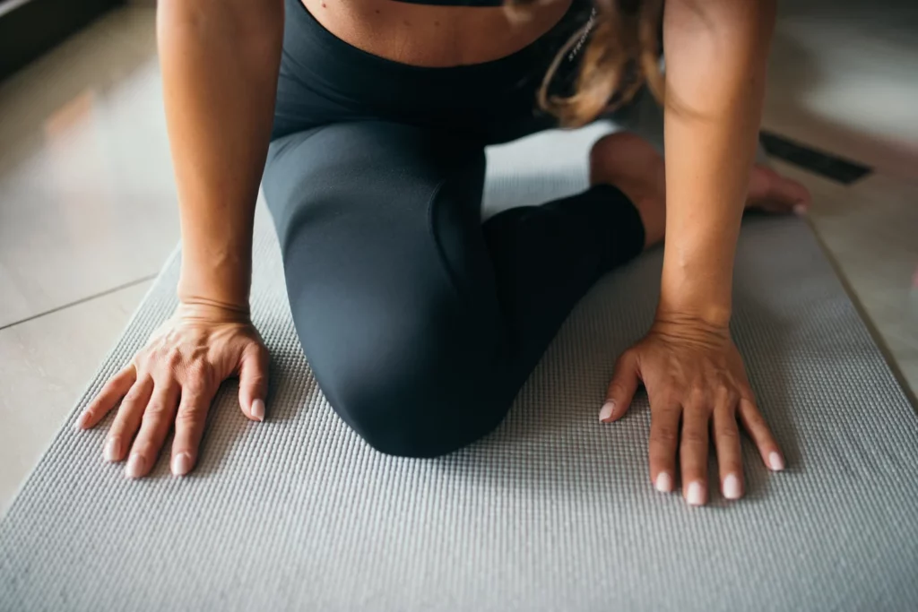 Sportive réalisant un exercice de mobilité de la hanche sur un tapis