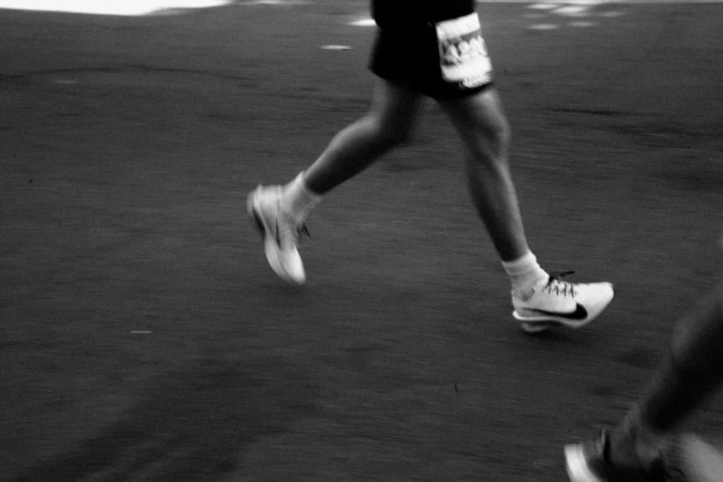 Jambes d'un coureur en mouvement illustrant les symptômes déclenchés à l'effort