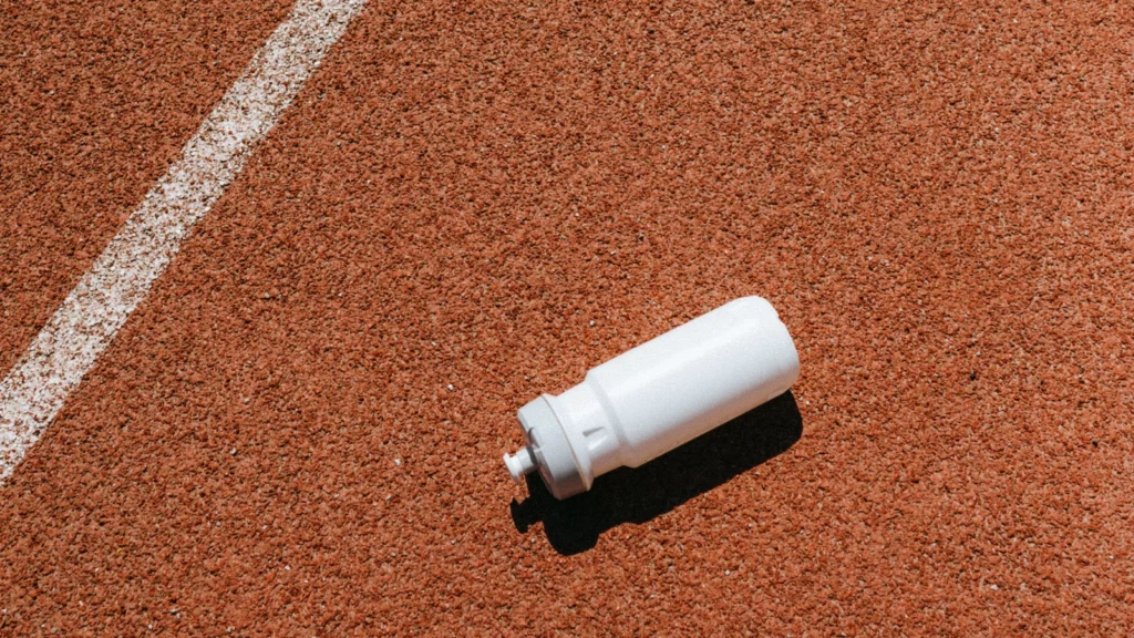 Bidon sans marque posé sur une piste de course à pied
