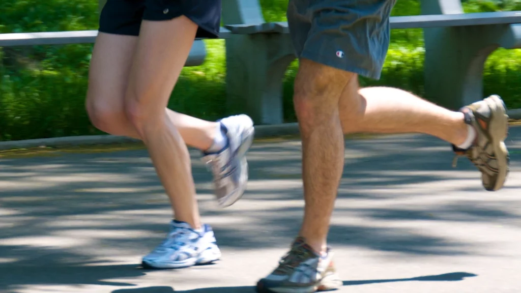 Jambes de deux coureurs avançant ensemble à allure facile